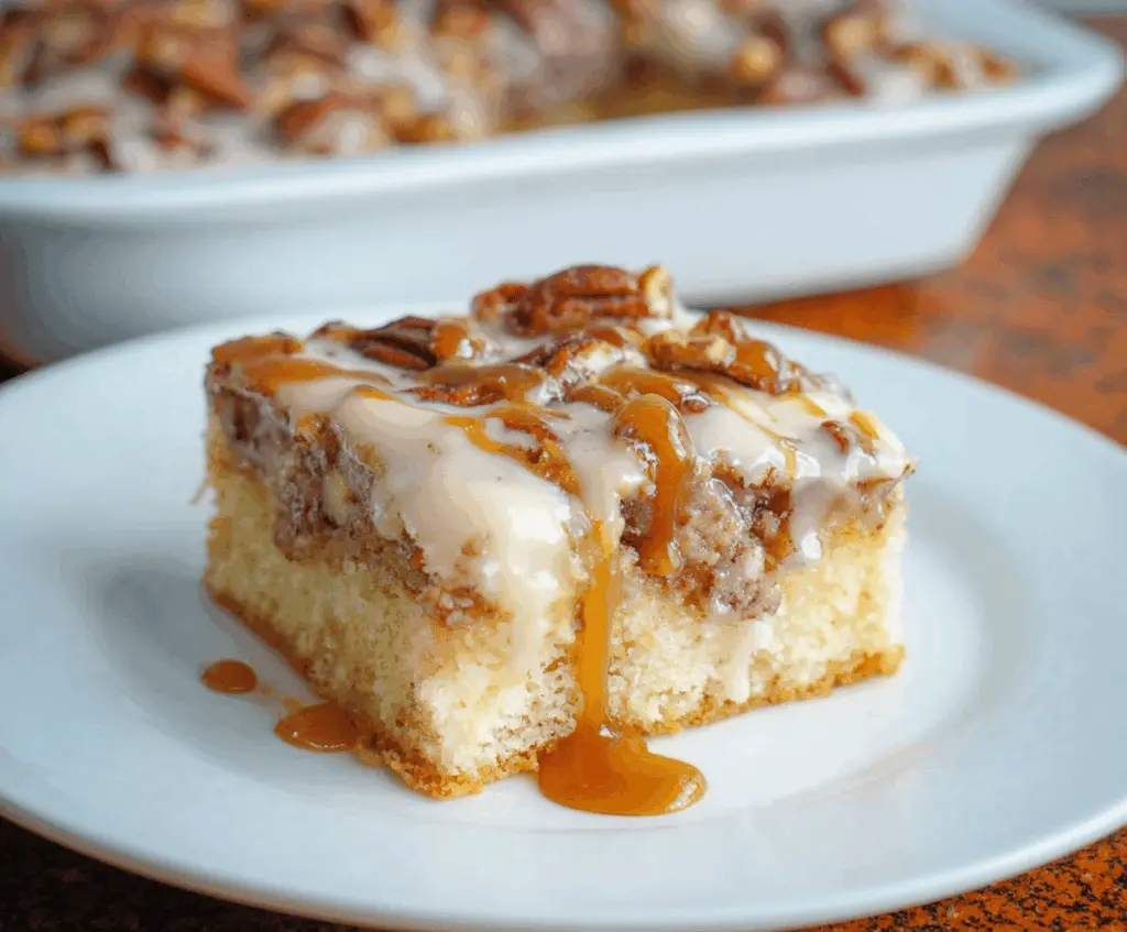 Delicious Butter Pecan Praline Poke Cake topped with whipped cream and toasted pecans, showcasing a rich caramel and nutty flavor perfect for dessert lovers.
