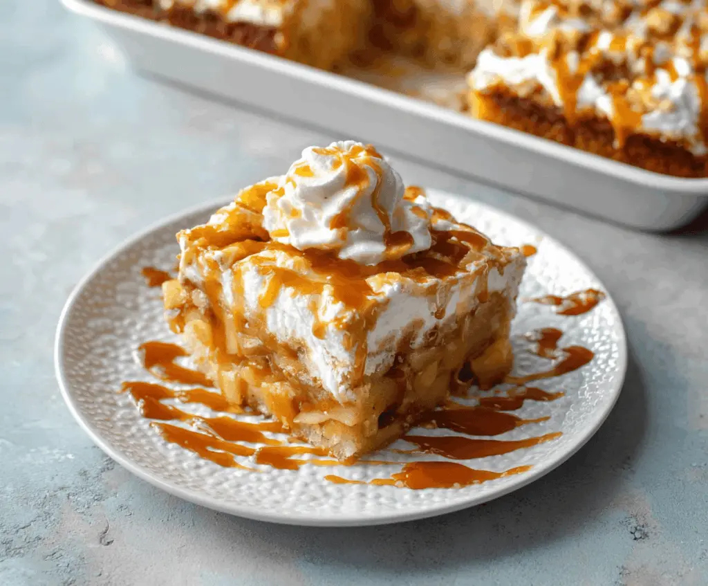 Delicious Caramel Apple Poke Cake topped with caramel sauce and apple slices, perfect for fall dessert