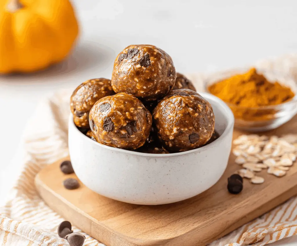 Healthy Espresso Pumpkin Protein Balls with chocolate chips on a wooden surface, perfect for a nutritious snack