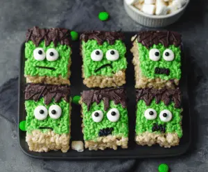 Colorful Frankenstein Rice Krispie Treats decorated with green frosting, googly eyes, and candy bolts, perfect for Halloween parties.